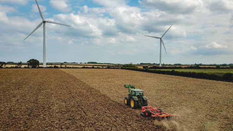 Tractor en un campo arando, políticas de precios en el sector agrario