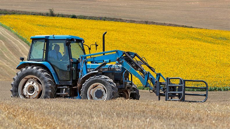 Un tractor pasa sobre los campos segados en Zaragoza. Efeagro/Javier Belver
