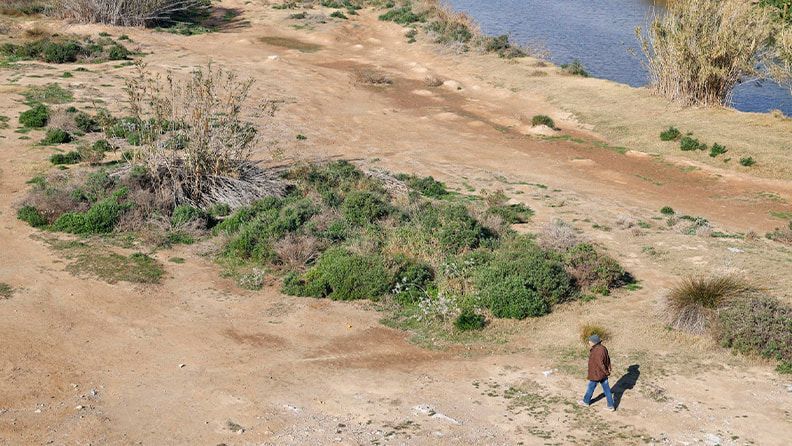 Una persona pasea por el margen urbanizado del rio Llobregat en El Prat del Llobregat, este jueves. EFE/Quique García